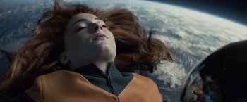 Movie still from “Dark Phoenix” (2019), directed by Simon Kinberg – A woman laying on top of the earth with her eyes closed; Close Up shot, Overhead angle