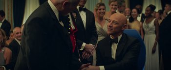 Movie still from “Dark Phoenix” (2019), directed by Simon Kinberg – Two men shaking hands in front of a group of people; Medium shot, Over the shoulder angle