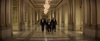 Movie still from “Dark Phoenix” (2019), directed by Simon Kinberg – A group of men walking down a hall way; Wide shot, Low angle