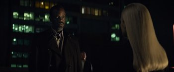 Movie still from “Dark Phoenix” (2019), directed by Simon Kinberg – A man in a trench coat standing in front of a building at night; Medium shot, Over the shoulder angle