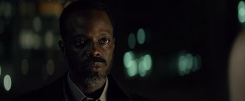 Movie still from “Dark Phoenix” (2019), directed by Simon Kinberg – A man in a suit and tie in front of blurry lights; Close Up shot, Low angle