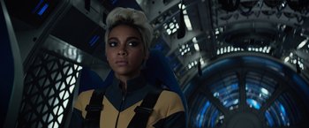 Movie still from “Dark Phoenix” (2019), directed by Simon Kinberg – A woman in a yellow and black jacket looking into the distance; Close Up shot, Over the shoulder angle