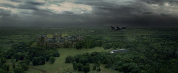 Movie still from “Dark Phoenix” (2019), directed by Simon Kinberg – An airplane flying over a large building in a field; Extreme Wide shot, High angle