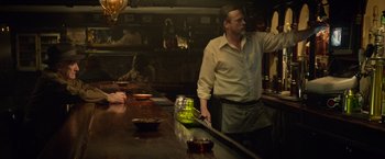 Movie still from “Dark Phoenix” (2019), directed by Simon Kinberg – A man standing at a bar with a glass of beer; Medium shot, Over the shoulder angle