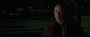 Movie still from “Dark Phoenix” (2019), directed by Simon Kinberg – A man with a bald head is standing in the dark; Close Up shot, Over the shoulder angle