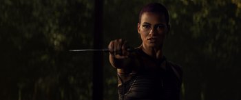 Movie still from “Dark Phoenix” (2019), directed by Simon Kinberg – A woman with purple hair is holding a sword; Close Up shot, Over the shoulder angle