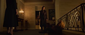 Movie still from “Dark Phoenix” (2019), directed by Simon Kinberg – A woman standing in a living room in front of a painting; Wide shot, Low angle