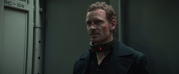 Movie still from “Dark Phoenix” (2019), directed by Simon Kinberg – Michael fassbender wearing a neck brace; Close Up shot, Low angle