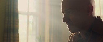 Movie still from “Dark Phoenix” (2019), directed by Simon Kinberg – A man with a bald head looking to his left; Close Up shot, Low angle