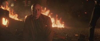 Movie still from “Dark Phoenix” (2019), directed by Simon Kinberg – A bald man in front of a fire pit; Medium shot, Low angle