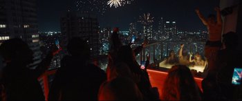 Movie still from “To Catch a Killer” (2023), directed by Damián Szifron – A group of people sitting on top of a building at night; Extreme Wide shot, Low angle