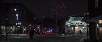 Movie still from “To Catch a Killer” (2023), directed by Damián Szifron – A street scene with fireworks in the background; Extreme Wide shot, High angle