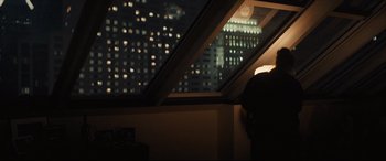 Movie still from “To Catch a Killer” (2023), directed by Damián Szifron – A person is looking out of a window at night; Medium shot, Low angle