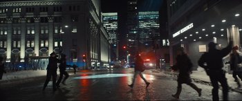Movie still from “To Catch a Killer” (2023), directed by Damián Szifron – A person walking across a wet street at night; Extreme Wide shot, High angle