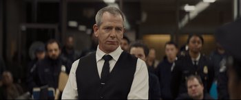 Movie still from “To Catch a Killer” (2023), directed by Damián Szifron – A man wearing a black vest and a white shirt; Close Up shot, Over the shoulder angle