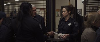 Movie still from “To Catch a Killer” (2023), directed by Damián Szifron – Two police officers serving coffee from a tray; Medium shot, Over the shoulder angle