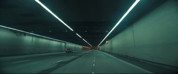 Movie still from “To Catch a Killer” (2023), directed by Damián Szifron – A car is driving through a tunnel at night; Extreme Wide shot, High angle
