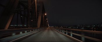 Movie still from “To Catch a Killer” (2023), directed by Damián Szifron – A long bridge that has lights on it at night time; Extreme Wide shot, High angle