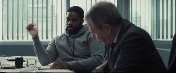 Movie still from “To Catch a Killer” (2023), directed by Damián Szifron – Two men sitting at a table looking at a book; Medium shot, Over the shoulder angle