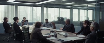 Movie still from “To Catch a Killer” (2023), directed by Damián Szifron – A group of people sitting at a table in an office; Wide shot, Over the shoulder angle