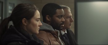 Movie still from “To Catch a Killer” (2023), directed by Damián Szifron – A man and two women are standing in a room; Close Up shot, Over the shoulder angle