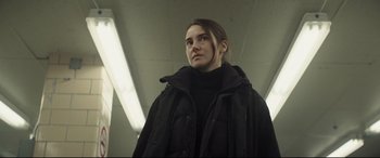 Movie still from “To Catch a Killer” (2023), directed by Damián Szifron – A person wearing a black jacket standing under a bridge; Medium shot, Low angle