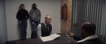 Movie still from “To Catch a Killer” (2023), directed by Damián Szifron – A man sitting at a table in front of another man; Medium shot, Over the shoulder angle