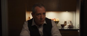 Movie still from “To Catch a Killer” (2023), directed by Damián Szifron – A person sitting in front of a counter; Close Up shot, Over the shoulder angle