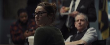 Movie still from “To Catch a Killer” (2023), directed by Damián Szifron – A woman wearing glasses and a green sweater; Close Up shot, Over the shoulder angle