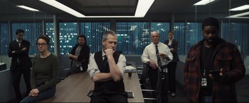 Movie still from “To Catch a Killer” (2023), directed by Damián Szifron – A group of people sitting in a conference room at night; Wide shot, Over the shoulder angle