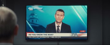 Movie still from “To Catch a Killer” (2023), directed by Damián Szifron – A television screen showing a man in a suit and tie; Extreme Close Up shot, High angle