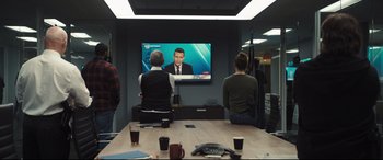 Movie still from “To Catch a Killer” (2023), directed by Damián Szifron – A man and a woman are watching television; Medium shot, Over the shoulder angle