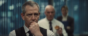 Movie still from “To Catch a Killer” (2023), directed by Damián Szifron – A person wearing a suit and tie; Close Up shot, Over the shoulder angle