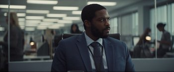 Movie still from “To Catch a Killer” (2023), directed by Damián Szifron – A man in a suit and tie sitting in a chair; Medium shot, Over the shoulder angle