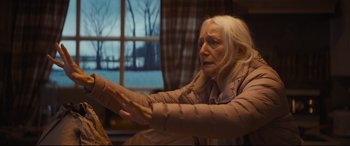 Movie still from “To Catch a Killer” (2023), directed by Damián Szifron – An older woman sitting in a chair in front of a window; Medium shot, Over the shoulder angle