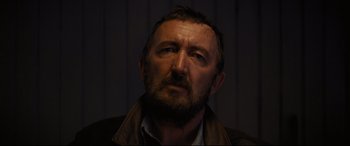 Movie still from “To Catch a Killer” (2023), directed by Damián Szifron – A person wearing a jacket; Close Up shot, Low angle
