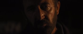 Movie still from “To Catch a Killer” (2023), directed by Damián Szifron – A person with a beard looking at the camera; Close Up shot, Low angle