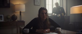 Movie still from “To Catch a Killer” (2023), directed by Damián Szifron – A woman sitting at a table with two cups of coffee; Medium shot, Over the shoulder angle