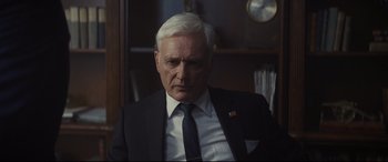 Movie still from “To Catch a Killer” (2023), directed by Damián Szifron – An older man wearing a suit and tie; Close Up shot, Low angle