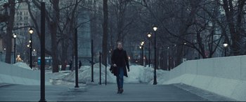 Movie still from “To Catch a Killer” (2023), directed by Damián Szifron – A woman walking down a sidewalk in the snow; Wide shot, Over the shoulder angle