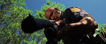 Movie still from “Dawn of the Dead” (2004), directed by Zack Snyder – A man in a police uniform is holding a gun; Close Up shot, Low angle