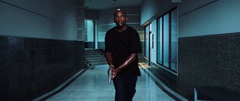 Movie still from “Dawn of the Dead” (2004), directed by Zack Snyder – A man in a black t - shirt is holding a gun; Medium shot, Low angle