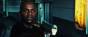 Movie still from “Dawn of the Dead” (2004), directed by Zack Snyder – A man holding a gun while standing in a room; Close Up shot, Low angle