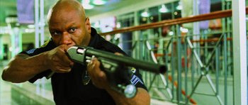 Movie still from “Dawn of the Dead” (2004), directed by Zack Snyder – A police officer is holding a rifle in his hands; Close Up shot, Low angle
