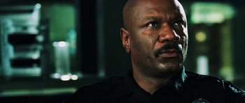 Movie still from “Dawn of the Dead” (2004), directed by Zack Snyder – A person wearing a black uniform; Close Up shot, Low angle