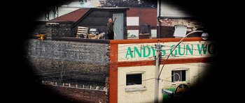 Movie still from “Dawn of the Dead” (2004), directed by Zack Snyder – A man standing on top of a brick building; Wide shot, High angle
