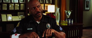 Movie still from “Dawn of the Dead” (2004), directed by Zack Snyder – A police officer is sitting in front of a table; Close Up shot, Over the shoulder angle