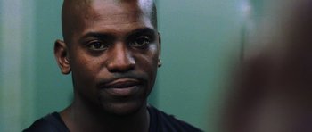 Movie still from “Dawn of the Dead” (2004), directed by Zack Snyder – A man's face in front of a green wall; Close Up shot, Low angle