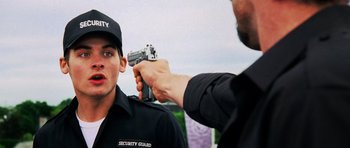 Movie still from “Dawn of the Dead” (2004), directed by Zack Snyder – A man holding a gun pointed at a man in a security guard uniform; Close Up shot, Over the shoulder angle
