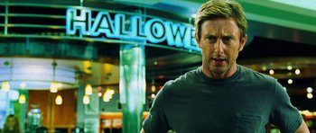 Movie still from “Dawn of the Dead” (2004), directed by Zack Snyder – A man standing in front of a neon sign; Close Up shot, Low angle